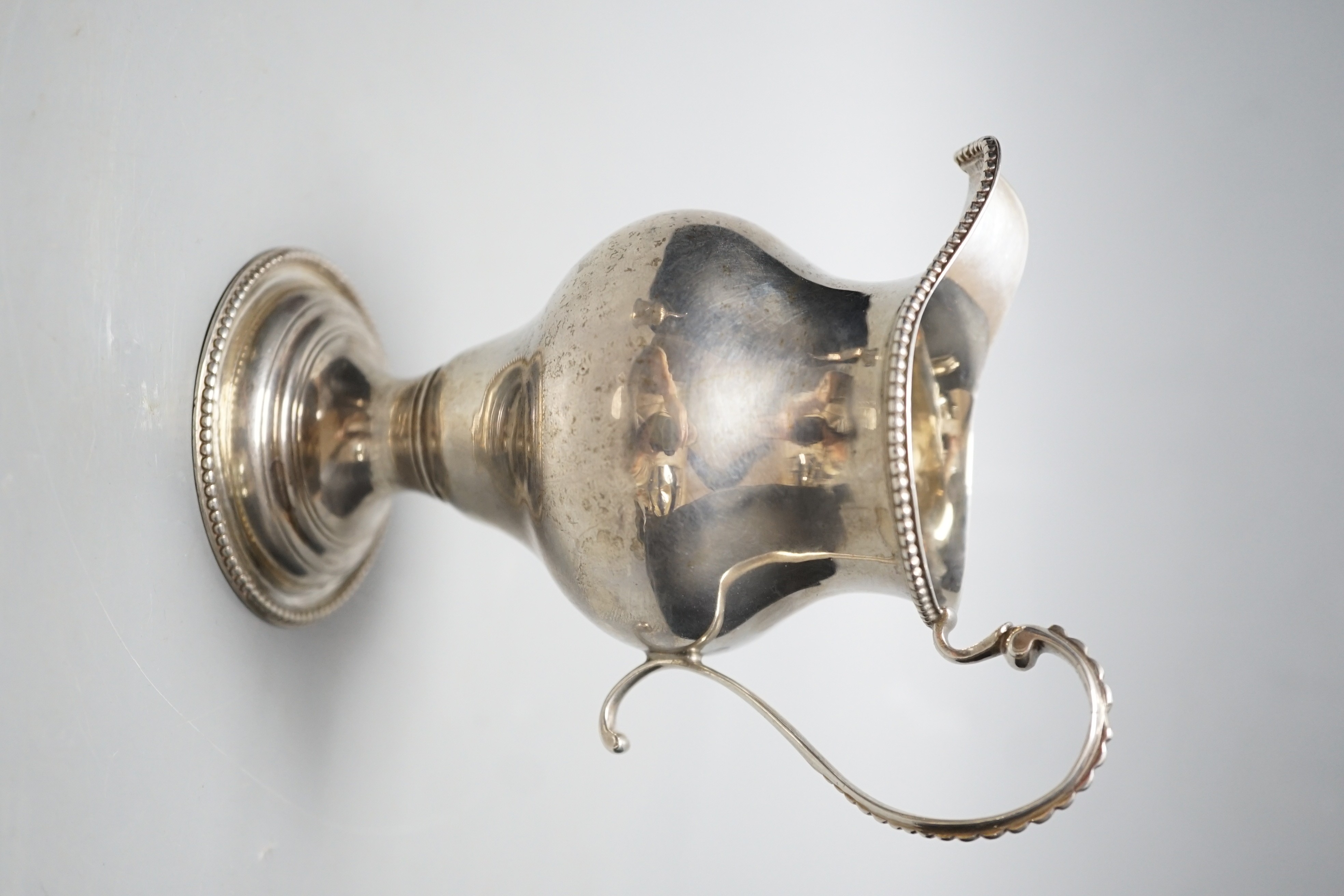 A George III silver inverted pear shaped cream jug, London, 1779, 31.1cm, maker's mark rubbed.